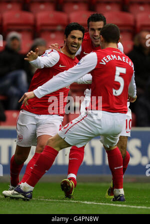 Arsenals Mikel Arteta feiert sein Tor mit Arsenals Robin Van Persie (Mitte) und Thomas Vermaelen (rechts) während des Barclays Premier League-Spiels im DW Stadium, Wigan. Stockfoto