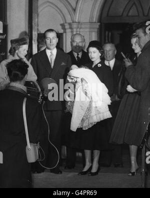 Königin Elizabeth II. Hält als Patin das Baby George Herbert, den Sohn ihres Jugendfreundes Lord Porchester, links nach der Taufe in der St. Paul's Church, Knightsbridge, London. Stockfoto