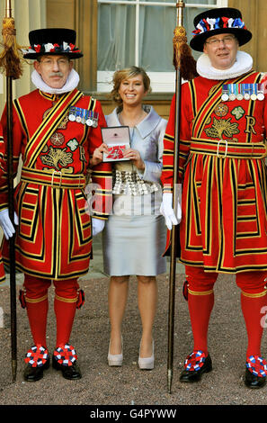 Brooke Kinsella steht mit zwei Mitgliedern der Leibgarde der Königin der Yeoman of the Guard, nachdem sie während einer Investiturzeremonie im Buckingham Palace in London vom Prince of Wales mit einem MBE ausgezeichnet wurde. Stockfoto