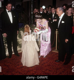 Königin Elizabeth II. Freut sich, einen Blumenstrauß von Amanda Jane Smythe zu erhalten, die als Kind Elizabeth im Film „Anne of a Thousand Days“ bei der Royal Film Performance im Odeon, Leicester Square, London, auftritt. Stockfoto