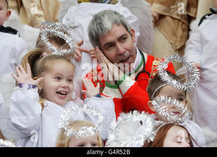 Oberbürgermeister Andrew Montague begleitet als Engel gekleidete Kinder von der St. Josephs Nursery zum Singen von Weihnachtsliedern, da die traditionelle lebende Tierkrippe, die von der Irish Farmers Association bereitgestellt wird, im Herrenhaus in Dublin eröffnet wird. Stockfoto