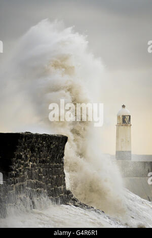Riesige Wellen stürzen gegen die Hafenmauer und verschlingen den Leuchtturm in Porthcawl, South Wales, während starke Winde und Regen den Südwesten Großbritanniens überschwemmen. Stockfoto