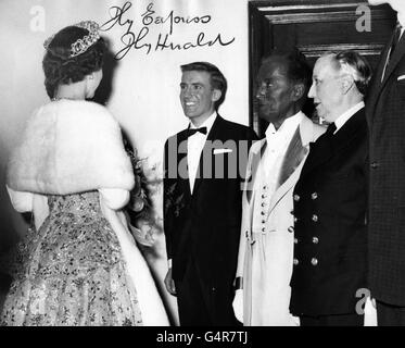 Queen Elizabeth II trifft Roy Castle, links, am London Coliseum bei der Royal Variety Performance. Mit Roy Castle sind der männliche Imitator Hetty King (rechts) und G.H Elliott, ein britischer Sänger und Tänzer in der Musikhalle, bekannt für seine gemalte Blackface. Stockfoto