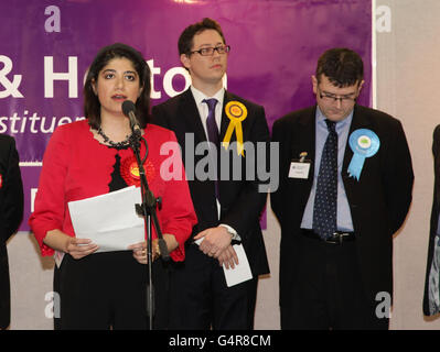 RÜCKÜBERTRAGUNG ZUR ÄNDERUNG VON THEMA UND SCHLÜSSELWORT Labour-Kandidat Seema Malhotra hält eine Rede, nachdem er die Nachwahl in Feltham und Heston gewonnen hat (die durch den Tod des langjährigen Labour-Abgeordneten Alan Keen im vergangenen Monat ausgelöst wurde, nachdem er seinen Kampf gegen Krebs verloren hatte), als erfolglose Kandidaten Roger Crouch (Mitte, Liberaldemokraten) Und Mark Bowen (Konservativer) schaut auf, im Civic Center in Hounslow, West London. Stockfoto