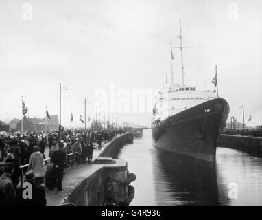 An den Dockseiten versammeln sich Menschenmassen, während die Royal Yacht Britannia, die Königin Elizabeth II. Und den Herzog von Edinburgh trägt, auf dem Weg nach Amsterdam durch eine Schleuse des Nordseekanals in Ijmuiden führt Stockfoto