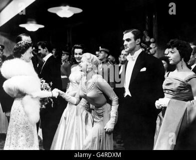 Queen Elizabeth II schüttelt die Hände mit der Hollywood-Schauspielerin Jayne Mansfield bei der Royal Film Performance von 'Les Girls' im Odeon, Leicester Square, London. Andere Stars, von links nach rechts, Anne Heywood, Stanley Baker und Dorothy Tutin. Stockfoto