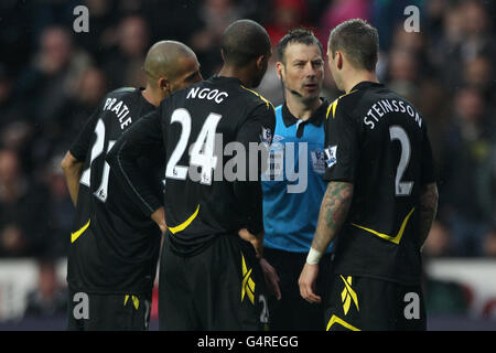 Schiedsrichter Mark Clattenburg (2. Rechts) hat Worte mit Bolton Wanderers' Darren Pratley (links), David Ngov (2. Links) und Gretar Rafn Steinsson (rechts) Stockfoto