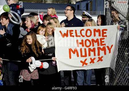 Die Familie wartet auf ihre Angehörigen, als HMS Ocean nach einer siebeneinhalb monatigen Tour, bei der die Besatzung Luftangriffe gestartet hat, die das Regime von Oberst Gaddafi in Libyen beenden konnten, in die Docks des Royal Naval Base Devonport Plymouth einzieht. Stockfoto