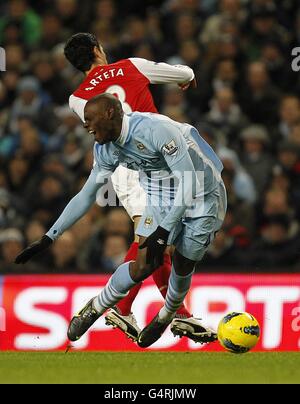 Fußball - Barclays Premier League - Manchester City / Arsenal - Etihad Stadium. Mario Balotelli von Manchester City wird von Mikel Arteta von Arsenal niedergeschlagen Stockfoto