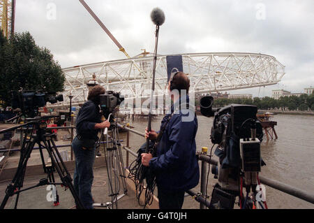 Eine Fernsehcrew sieht zu, wie das British Airways London Eye 10 Grad, etwa 100 Fuß, über der Themse in London angehoben wird, nachdem Ingenieure einen neuen Versuch gestartet haben, das Millenium-Riesenrad über den Fluss zu heben, einen Monat nachdem das letzte Angebot gescheitert war. * das Konstruktionsteam hofft, das Rad, das 1,500 Tonnen wiegt, in den nächsten zwei Tagen um 65 Grad anzuheben. Der neue Versuch begann, als die Arbeiter das Rad von den neun Stützplattformen befreiten, auf denen es ruht. Wenn alles nach Plan verläuft, wird erwartet, dass es bis zum Ende des Tages 30 Grad erreichen wird. Stockfoto