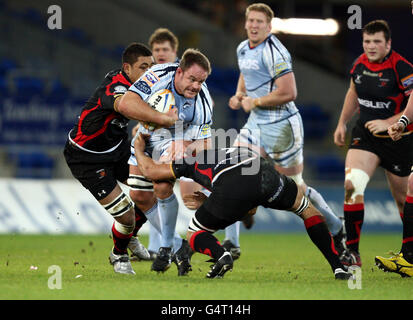 Xavier Rush von Cardiff Blues wird von Newport Gwent Dragons Toby Faletau und Gavin Thomas während des RaboDirect PRO12-Spiels im Cardiff City Stadium, Caridff, angegangen. Stockfoto