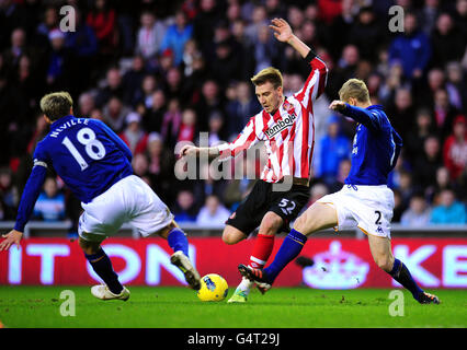 Nicklas Bendtner von Sunderland in Aktion mit Gary Neville von Everton und Tony Hibbert (rechts) während des Spiels der Barclays Premier League im Stadium of Light in Sunderland. Stockfoto