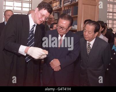 Chinas Präsident Jiang Zemin besucht die Universitätsbibliothek von Cambridge und wird von Charles Aylmer, dem Leiter des chinesischen Departements der Universität, begleitet, der dem Präsidenten die chinesischen Orakelknochen zeigt, die aus dem Jahr 1400 v. Chr. stammen und die ältesten Gegenstände in der Bibliothek sind. Stockfoto