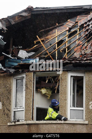 Ein Mann arbeitet in einem beschädigten Haus in der Crowhill Street, Glasgow, nachdem Großbritannien gestern von heftigen Stürmen heimgesucht wurde. Stockfoto