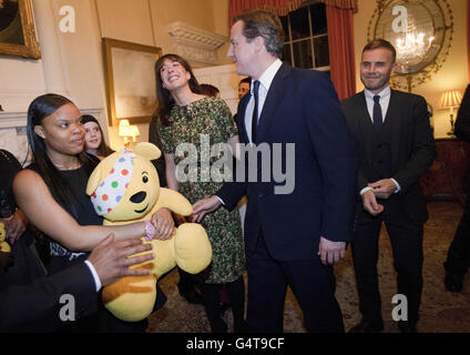 Premierminister David Cameron, Frau Samantha, zweite links, und Sänger Gary Barlow, rechts, treffen Gäste während eines Empfangs in der Downing Street 10 für Unterstützer und Nutznießer der BBC Children in Need Charity. Stockfoto