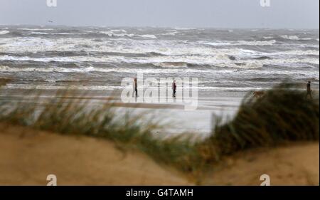 Einige Menschen trotzen dem schlechten Wetter am Freshfield Beach, Sefton, Merseyside. Stockfoto