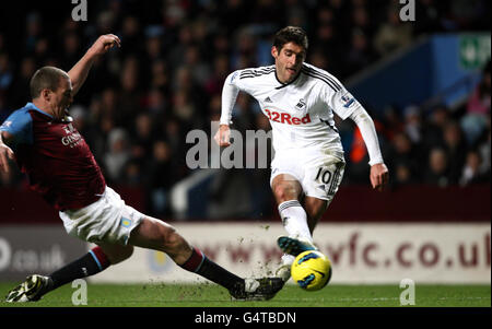 Danny Graham von Swansea City schießt, während Aston Villas Richard Dunne während des Spiels der Barclays Premier League in Villa Park, Birmingham, abfängt. Stockfoto