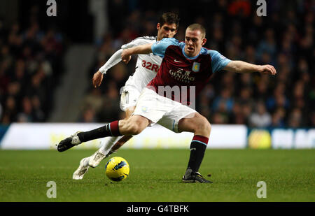 Richard Dunne von Aston Villa wird während des Spiels der Barclays Premier League in Villa Park, Birmingham, unter dem Druck von Danny Graham, Swansea City, geklart. Stockfoto