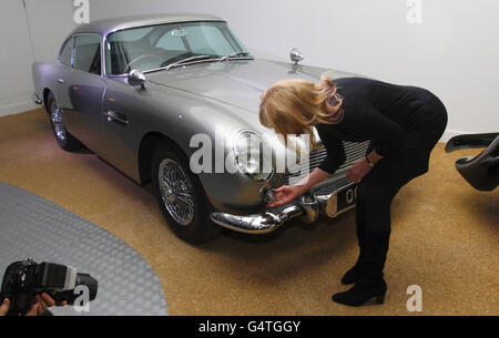 Das ehemalige Bond-Mädchen Britt Ekland inspiziert die Maschinengewehre hinter dem Anzeigelicht des ursprünglichen Aston Martin DB5 in einer neuen Ausstellung, Bond in Motion, im National Motor Museum, Beaulieu im New Forest, Hampshire. Stockfoto