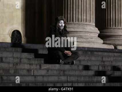 Occupy London Stock Exchange Protest. Ein Protestler, der eine Maske an der Stelle von Occupy vor der St. Paul's Cathedral in der City of London trägt Stockfoto