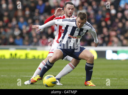 Simon Cox (rechts) von West Bromwich Albion hält Marc Wilson von Stoke City während des Barclays Premier League-Spiels im Britannia Stadium, Stoke on Trent, zurück. Stockfoto