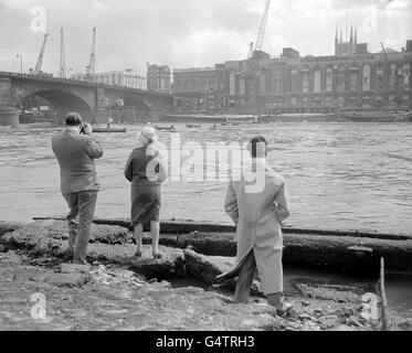 Drei Zuschauer beobachten den Beginn des 245. Doggett's Coat and Badge Race an der London Bridge. DOGGETT's Coat and Badge ist der Preis und Name für das älteste Ruderrennen der Welt Stockfoto