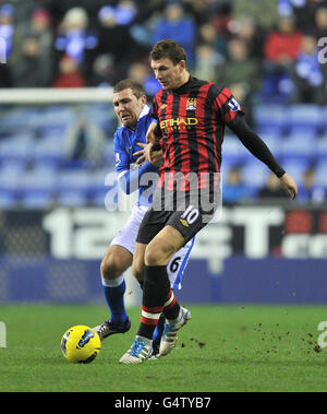 Edin Dzeko (rechts) von Manchester City kämpft mit James McArthur von Wigan Athletic während des Spiels der Barclays Premier League im DW Stadium in Wigan um den Ball. Stockfoto