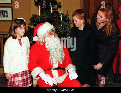 Die Herzogin von York mit ihren Töchtern, Prinzessin Beatrice und Prinzessin Eugenie (links), halten an, um mit dem Weihnachtsmann auf der National Society for the Prevention of Cruelty to Children Party im Cafe Royal in London zu plaudern. Stockfoto