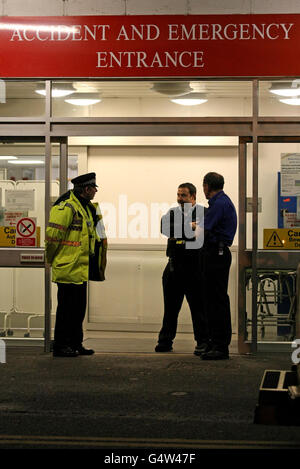 Ein Polizeibeamter steht vor der A&E-Abteilung des West Suffolk Hospital in Bury St. Edmunds, als heute Abend eine Menschenjagd im Gange war, nachdem zwei Gefängnisbeamte mit Waffengewalt bedroht und gezwungen wurden, einen Gefangenen freizulassen, Das geschah, als sie Andrew Farden, 26, zur Behandlung im Krankenhaus transportierten. Stockfoto