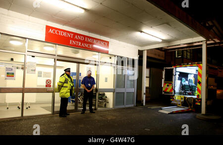 Ein Polizeibeamter steht vor der A&E-Abteilung des West Suffolk Hospital in Bury St. Edmunds, als heute Abend eine Menschenjagd im Gange war, nachdem zwei Gefängnisbeamte mit Waffengewalt bedroht und gezwungen wurden, einen Gefangenen freizulassen, Das geschah, als sie Andrew Farden, 26, zur Behandlung im Krankenhaus transportierten. Stockfoto