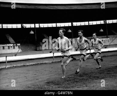 Roger Bister (vorne) wird während einer Trainingseinheit in der Weißen Stadt die Oxford University gegen Cambridge beim Inter-Varsity Mile Event in der Weißen Stadt in London vertreten. Stockfoto