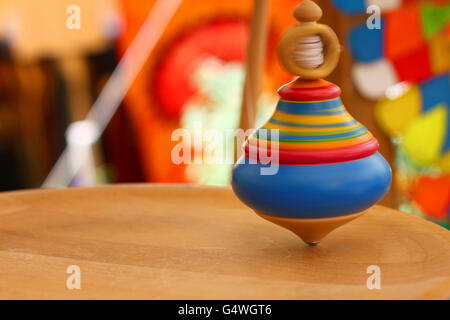 Kreisel. Ein Holz-Kreisel in Aktion auf einem Holztisch handgefertigt. Stockfoto