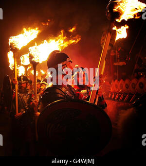 Mitglieder der Jarl-Truppe in Wikingerkostümen mit brennender Fackel in Lerwick auf den Shetland-Inseln während des Up Helly AA Viking Festivals. Stockfoto