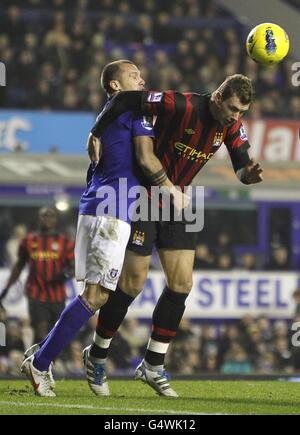 Fußball - Barclays Premier League - Everton gegen Manchester City - Goodison Park. Evertons John Heitinga (links) und Edin Dzeko (rechts) von Manchester City in Aktion Stockfoto