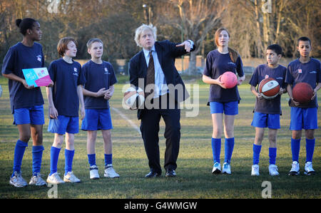 Der Londoner Bürgermeister Boris Johnson wirft Bälle in die Luft mit Schülern der Chiswick Community School im Westen Londons, wo er und der Londoner 2012-Vorsitzende Lord Coe der Schule mitteilten, wie viele olympische Tickets sie über das Londoner Ticketshare-Programm 2012 erhalten würden. Stockfoto