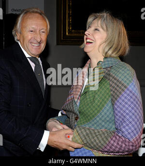 Der Ehrenvorsitzende des British Fashion Council (BFC), Harold Tillman (links), lacht mit Innenministerin Theresa May auf der London College of Fashion MA Show 2012 im Victoria and Albert Museum, London. Stockfoto