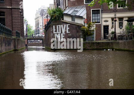 "LOVE ME" Graffiti an der Wand eine Wasserstraße Gracht in Amsterdam. Stockfoto