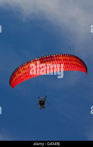 Niedrigen Winkel Ansicht der Person motor Paragliding vor einem klaren blauen Himmel und Wolken Stockfoto