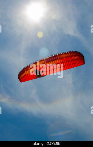 Niedrigen Winkel Ansicht der Person motor Paragliding gegen einen klaren, blauen Himmel und strahlende Sonne mit Blendenfleck Stockfoto