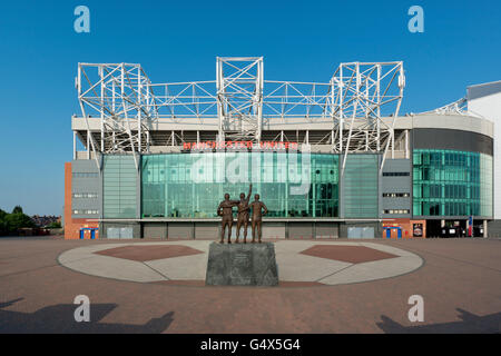 Old Trafford, das Stadion von Manchester United Football Club, mit der Trinity United-Statue an einem sonnigen Tag (nur zur redaktionellen Verwendung) Stockfoto