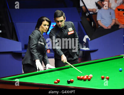 Der englische Ronnie O'Sullivan und die Schiedsrichterin Michaela Tabb untersuchen die Position der Kugeln auf dem Tisch während des Finales der Snooker-Weltmeisterschaft Betfred.com im Crucible Theatre, Sheffield. Stockfoto