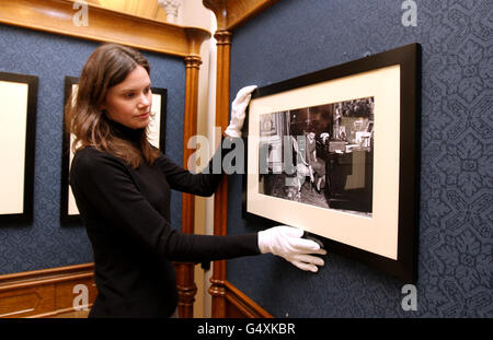 Die Mitarbeiterin der Royal Collection, Rachel Woolen, hängt mit einem ihrer Corgis, Teil der Queen, an ihrem Schreibtisch im Buckingham Palace ein Foto aus der Zeit von 1959 von The Queen: 60 Fotografien für 60 Jahre Ausstellung im Windsor Castle. Stockfoto