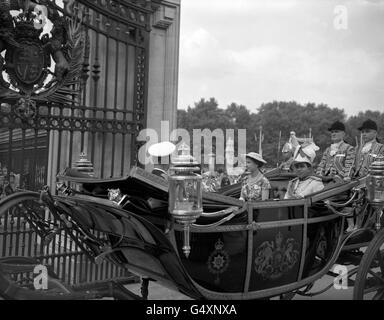 Königin Elizabeth II. Mit König Feisal vom Irak, der in einem offenen Wagen den Buckingham Palace betritt, während einer Prozession von Victoria Station zu Beginn seines Staatsbesuchs in Großbritannien. Stockfoto