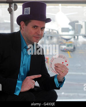 Der Zauberer Mike Stoner unterhält Passagiere an der Bar Crown Fluers im Terminal 5 des Flughafens Heathrow im Westen Londons, bevor sie zu ihren ausländischen Zielen fliegen. Stockfoto