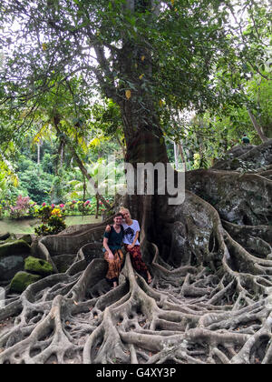 Indonesien, Bali, Gianyar, paar, sitzen auf Wurzeln eines heiligen Baums im Elefanten-Tempel Stockfoto