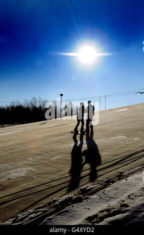 Eine Frau lernt Snowboard auf der trockenen Skipiste im Swadlincote Ski and Snowboard Centre, Derby. Stockfoto