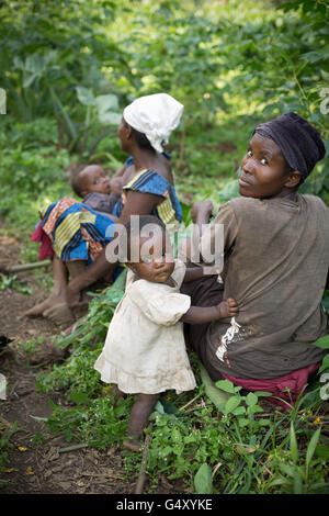 Bäuerinnen im Schatten auszuruhen, mit ihren Kindern in ländlichen Kasese District, Uganda, Ostafrika. Stockfoto