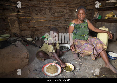 Mutter und Kind essen zusammen in ihrer Küche in Kasese District, Uganda. Stockfoto