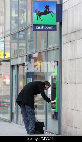 Gesamtansicht eines Mannes mit einem Lloyds Bank Cashpoint im Stadtzentrum von Manchester. Stockfoto