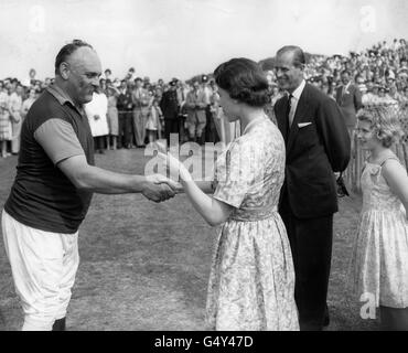 ** Low-res scanned off Print** Queen Elizabeth II präsentiert dem Komiker Jimmy Edwards einen dreifarbigen Bleistift als Trostpreis, nachdem sein Team, Ambersham, von Jersey Lillies beim Polo auf Smith's Lawn, Windsor Great Park besiegt wurde. Der Herzog von Edinburgh und Prinzessin Anne schauen sich in Belustigung an. Stockfoto
